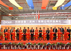 Crown and Chinese government officials cut ribbon at Suzhou plant opening.