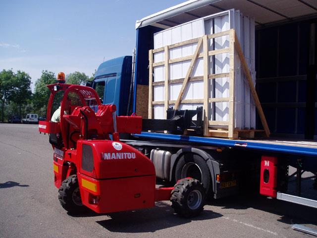 A Manitou truck-mounted forklift loading glass onto a truck.