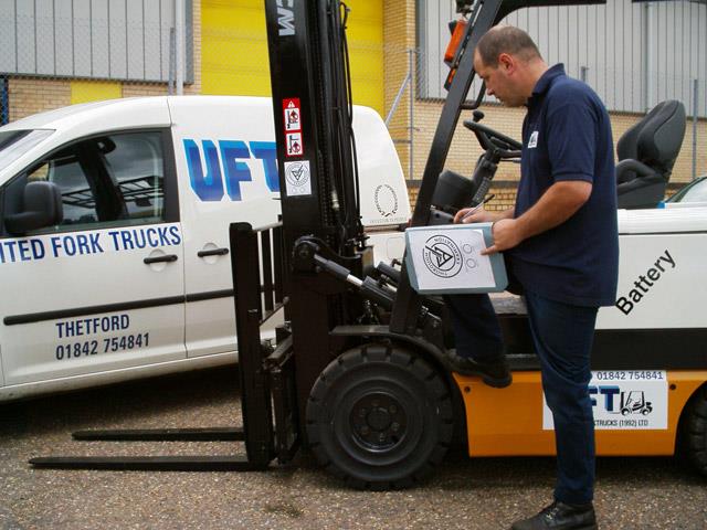 An inspector conducting a CFTS thorough examination of a forklift.