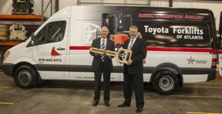 Lee Smith, dealer principal of Toyota Forklifts of Atlanta, accepts a new service van from Terry Rains, vice president of aftermarket sales for Toyota Material Handling.