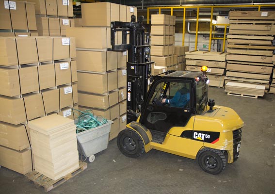 Lift truck driver, Seppo Tikkanen, moves stacked plywood boards to the production line.