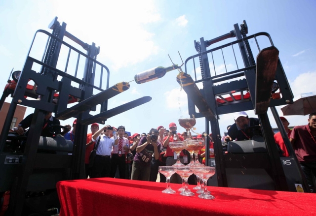 Linde forklifts pouring champagne by Benz. Click for larger image.