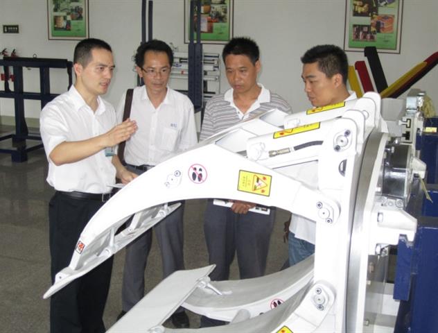 Cascade Xiamen employees demonstrating the benefits of a Cascade Paper Roll Clamp. Click to view larger image.