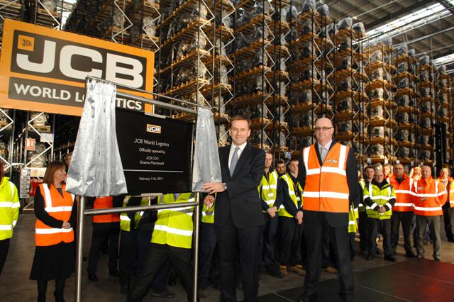 JCB CEO Graeme Macdonald unveils a plaque to mark the official opening of JCB World Logistics in Newcastle. Looking on is JCB group property director Alan Thomson and employees at the new facility.