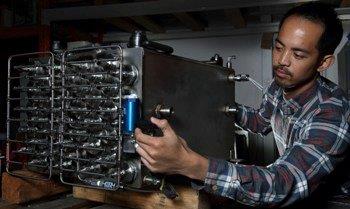 Adrian Narvaez of Hawaii Hydrogen Carriers with a metal hydride storage tank.<br />PHOTO: DINO VOURNAS