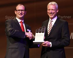 (L-R) Hans van Leeuwen from Toyota Material Handling Europe receiving an IFOY award from Dr Andreas Gruchow, board member for Deutsche Messe AG.