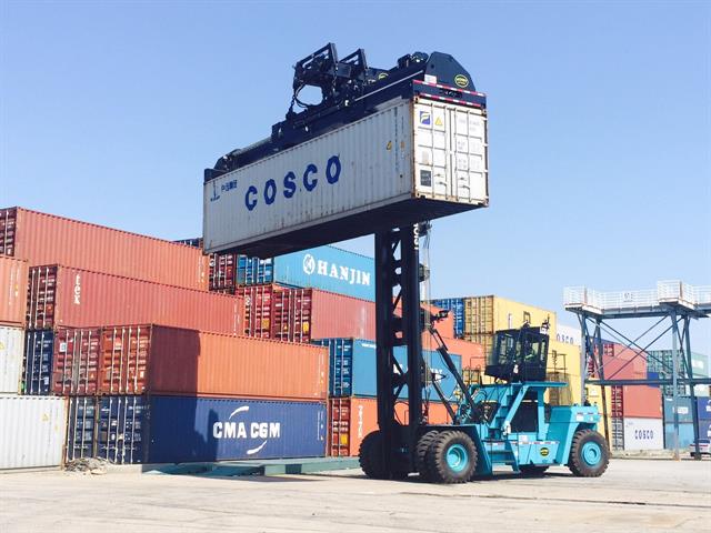Hoist top pick on a loaded container handler