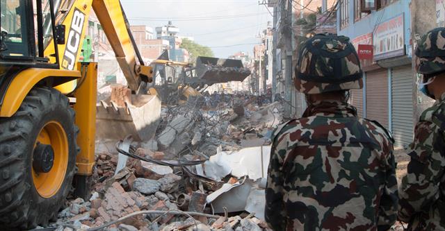 A JCB backhoe in Kathmandu, Nepal clearing debris from the site of a building that collapsed in the country's second earthquake.