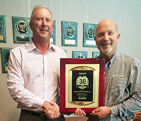 Jim Shoppa accepts Toyota Forklift 30-Year Partnership recognition plaque from John Snyder (right), South Central regional manager, Toyota.