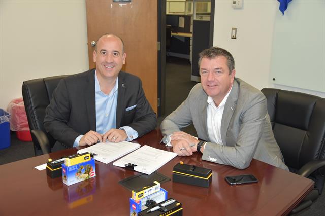 Michael Perkins (Volvo Car US Operations) and Vincent Halma (KION North America) sign the agreement.