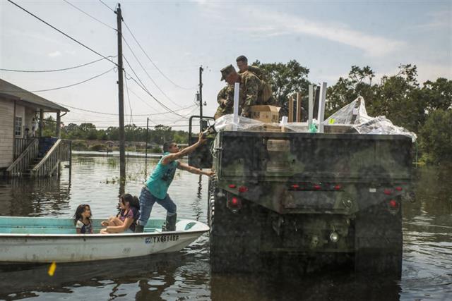 Marines hand supplies to a family in Orange, Texas during recovery and relief efforts following Hurricane Harvey. <br />Marine Corps photo by Lance Cpl. Niles Lee