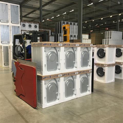 Bolzoni Auramo Carton Clamp handling washing machines at a logistic centre.