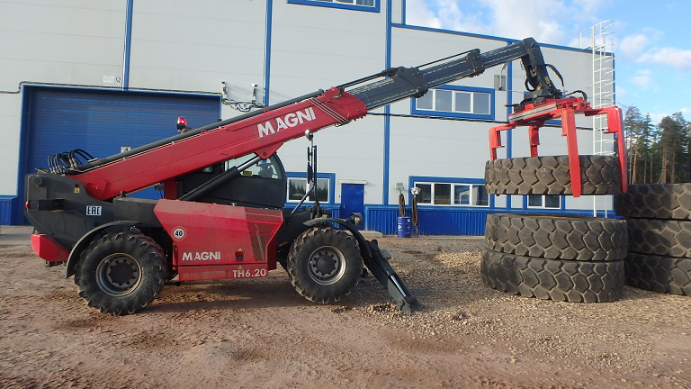 Telehandler tilting function to horizontally position tires.