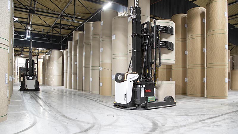 The AGV fleet stacks the paper rolls in assigned spaces in the warehouse.