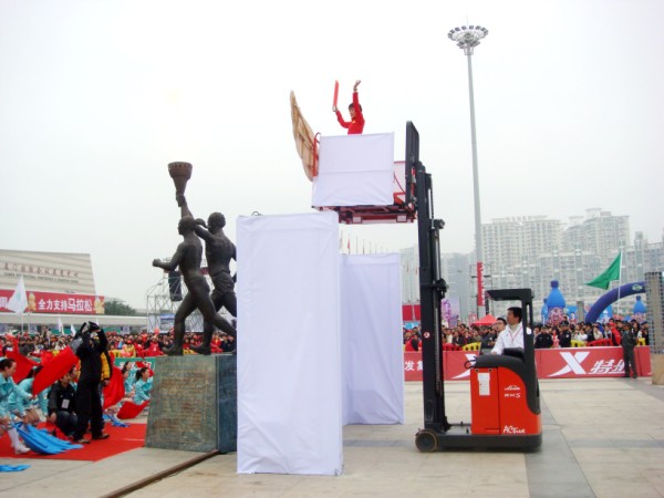 Bai Xue being lifted by the Linde reach truck during the torch-lighting ceremony.