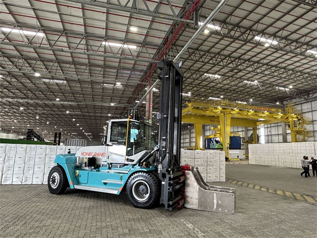 The forklifts use a clamp to lift pulp bales without pallets