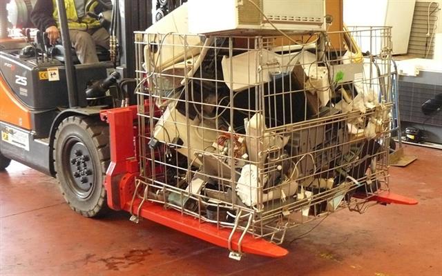 Bolzoni rotating fork clamp model KG-D employed to empty steel containers with electronic waste.