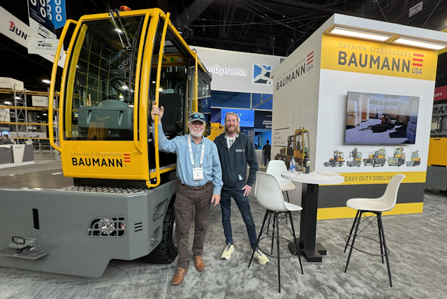 It's the last day at MODEX but Rob and Ford are still looking bright standing next to one of their sideloader forklifts.
