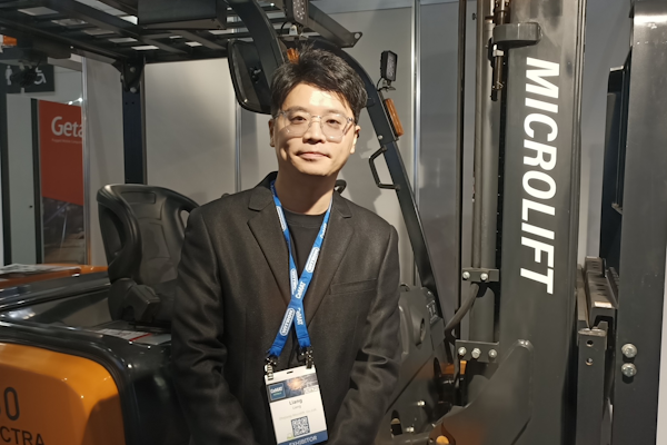 Leo Liang, Sales Manager at Microlift stands proud in front of their electric forklift on day one.