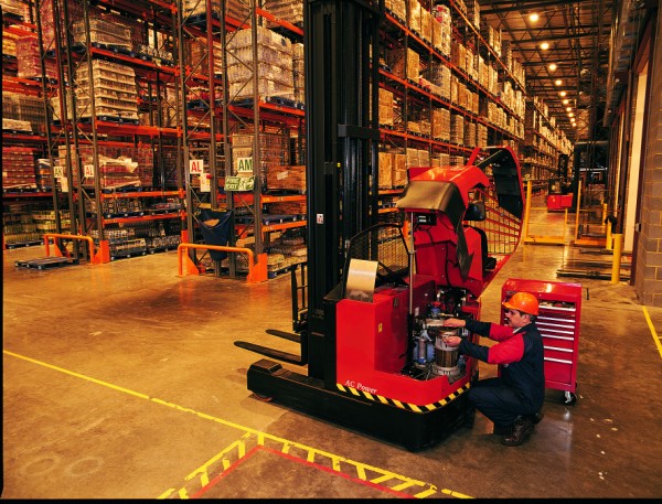 An engineer inspects a forklift in a UK warehouse.
