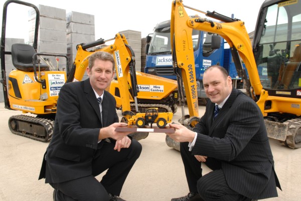 Tony Lees, TC Harrison JCB's commercial director presents a commemorative scale model JCB Loadall telescopic handler to Jackson Building Centre's group hire manager, Mark Shepherd.