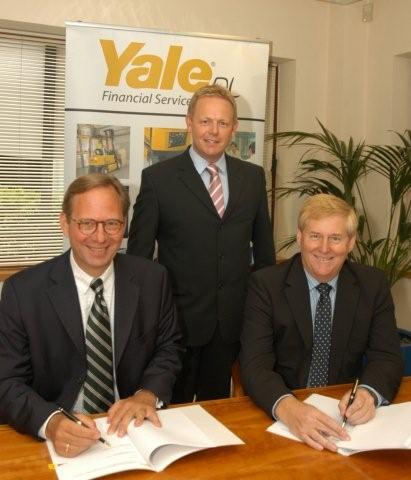 Ralf Mock and Martyn Fletcher sign the Yale Dealer Agreement, watched by David Bunting at Yale Europe's office in Fleet.