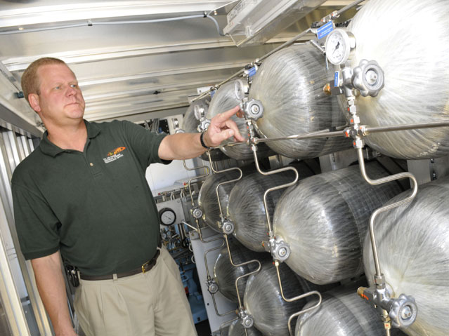Scott Slyfield examines hydrogen storage tanks inside the HyHauler. (photo by Sue Sapp)