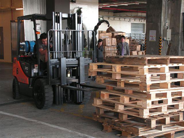 An operator trainee attempts to straighten a pallet stack while training with Ives in Macau, China.