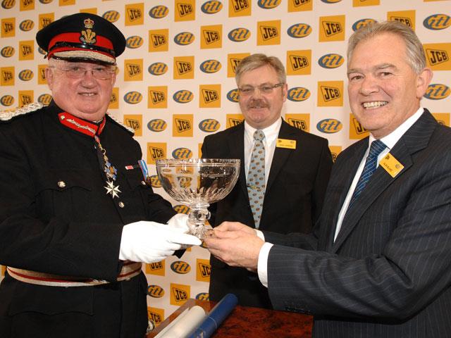 Trefor Jones presents Alan Blake with the Queen's Award watched by International Transmissions general manager Nigel Harding.