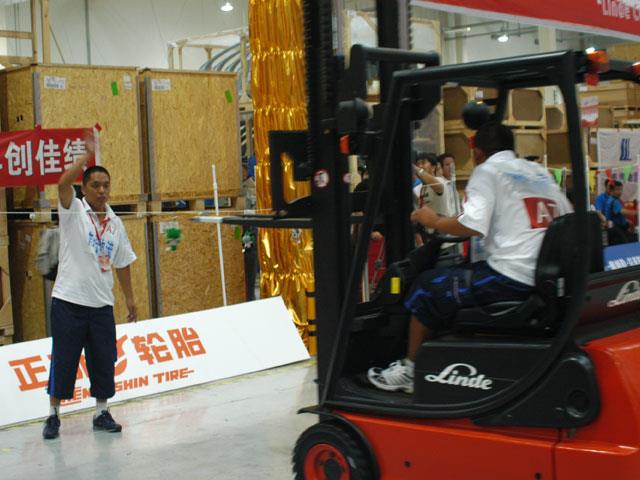 A Linde Cup participant handling Olympic mascot Fuwa (not shown) at various heights.