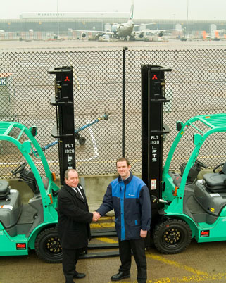 Servisair operations support manager Graeme Castle (right) thanks Brian Connor of LFTS (left) for the Mitsubishi forklifts.
