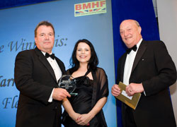 Narrow Aisle sales and marketing director John Maguire collects the BMHF Safety Award 2007 from Claire Mackay, business development manager of award sponsor NORCO. David Kendall, speaker at the BMHF Awards Dinner, looks on.