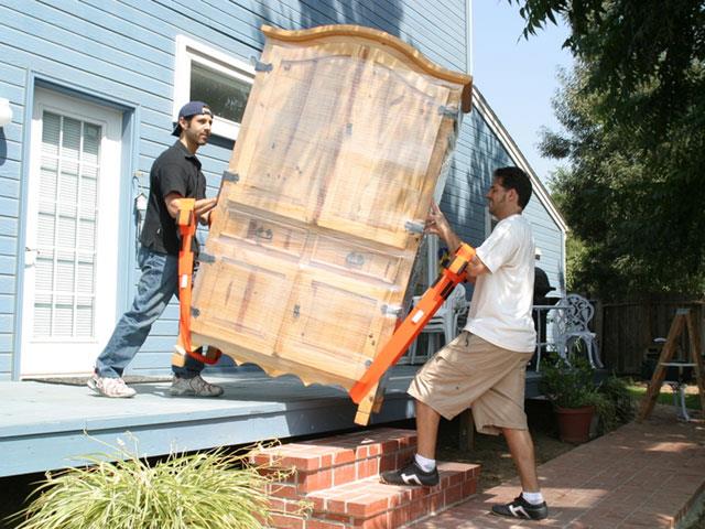 Two men carrying furniture with the forearm forklift