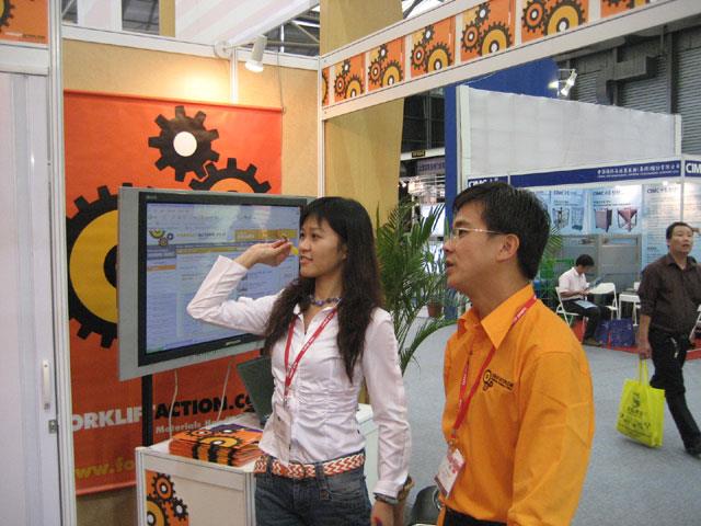 Patrick Chin shows a Forkliftaction.com stand visitor how to play darts.