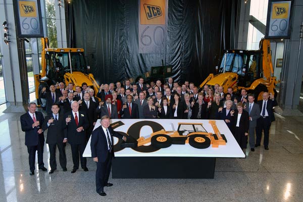 Anthony Bamford cuts the giant cake. Immediate left are JCB managing director and CEO John Patterson, product specialist George Heining and retired service director Bill Hirst.