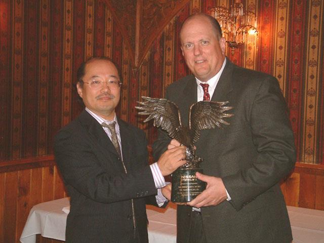 Nissan Forklift president Tok Tokugawa handing the 2004 President's Award to JM Equipment president David Baiocchi.