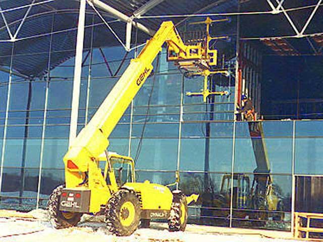 The Gehl DL-6H forklift with the 5 axis end-effector installing curtain wall panels in Grand Rapids, Michigan.