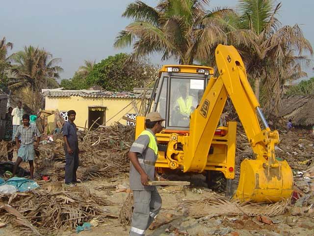 A JCB backhoe loader clearing debris in Chennai, Tamil Nadu, India