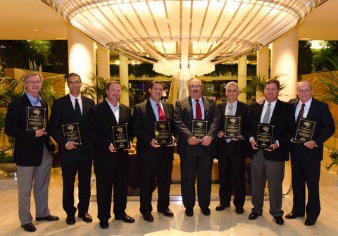 Representatives from nine Nissan forklift dealerships in North America holding their dealer of excellence awards.