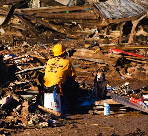 A rescue worker and his search dog sit outside the remains of the Plaza Towers Elementary School in Moore, OK.<br />U.S. Army photo by Oklahoma National Guard Maj. Geoff Legle