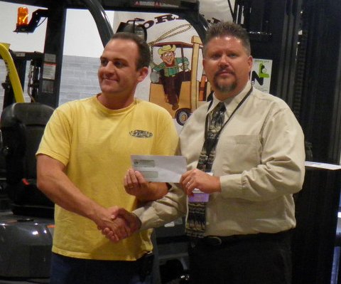 2012 grand champion Jeff Edmund (left) receives USD500 cheque from Tim Eacrett, materials handling/rodeo panel co-chairman.